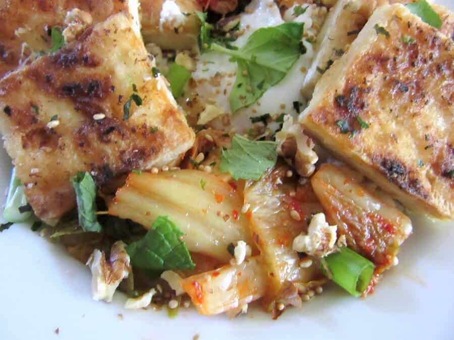 There's plenty of crunchy, tangy kimchi and fresh herbs in this spicy pan-fried tofu rice bowl. #tofu #ricebowl #kimchi #eggs