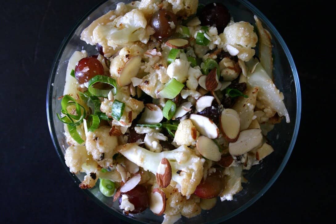 This cauliflower salad with pickled grapes, cheddar and almonds is perfect if you're in charge of bringing vegetables to a potluck, but aren't feeling a limp pile of lettuce again. #cauliflower #grapes #cheddar #almonds #vegetarian