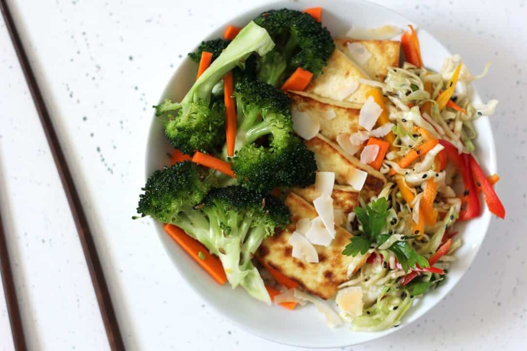 This coconut rice bowl with cumin broccoli slaw and quick pickles is the kind of lunch that makes you happy to have a bowl full of vegetables. #lunchideas #ricebowl #quickpickles #tofu #vegetables