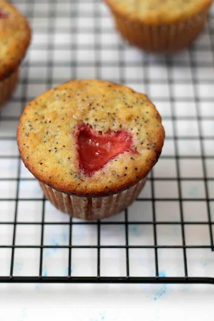 Sliced strawberries make the tops of these strawberry lemon poppy seed muffins pretty (and maybe perfect for Valentine's Day!). #strawberry #lemon #poppyseed #muffins #lemonpoppyseedmuffins
