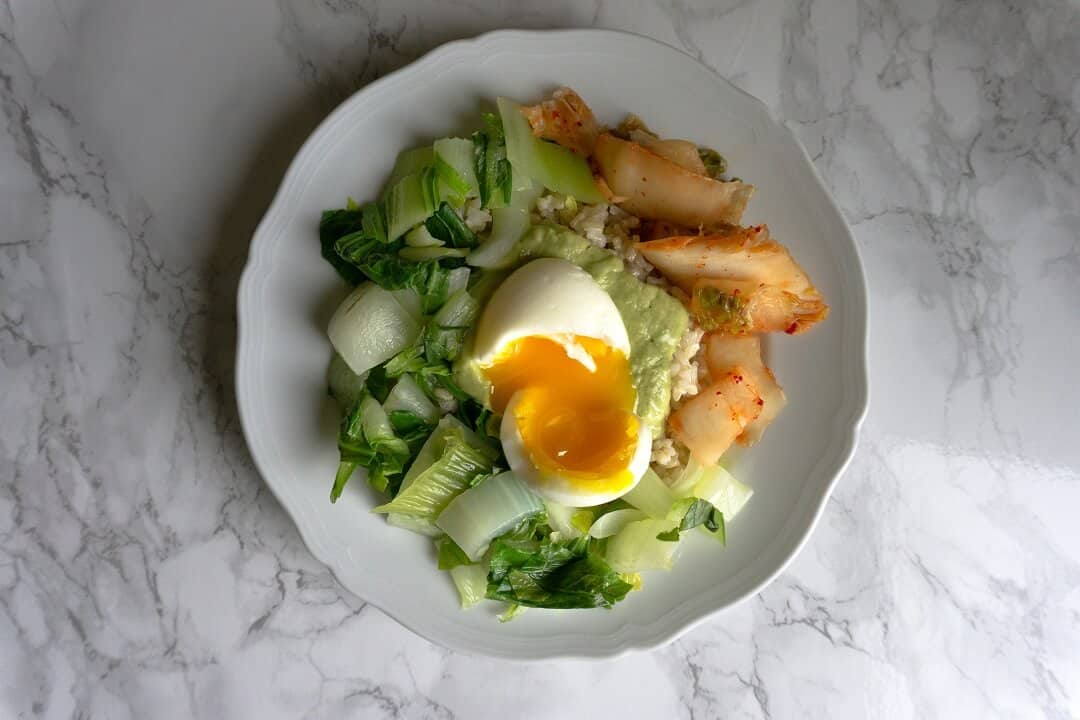 Tons of veggies, hearty brown rice and creamy eggs + avocado sauce. Sounds like a pretty satisfying lunch to me! #kimchi #ricebowl #lunchideas #runnyeggs
