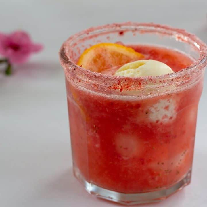 This strawberry citrus margarita float is delicious as is, but if you add some ground freeze dried strawberries to the rimming salt, you get another hit of fruity pink flavor! #strawberry #citrus #margarita #tequila