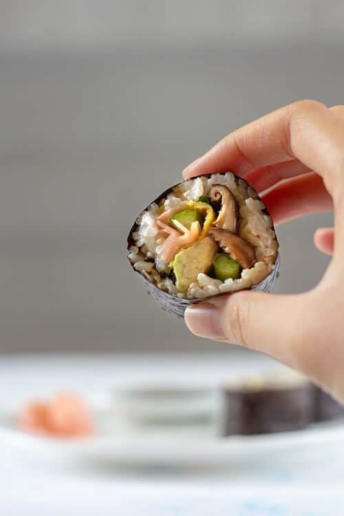 The main flavor in this shiitake mushroom and avocado sushi comes from the sauteed mushrooms and pickled ginger, but avocado and scrambled eggs help make this a heartier roll. #mushrooms #avocado #sushi #vegetarian