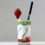 Clear glass with 3 layers: red strawberry compote, creamy milk and green matcha.