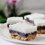 Three layer pie bars with a golden brown shortbread crust, bright purple sweet potato filling and creamy white coconut topping.