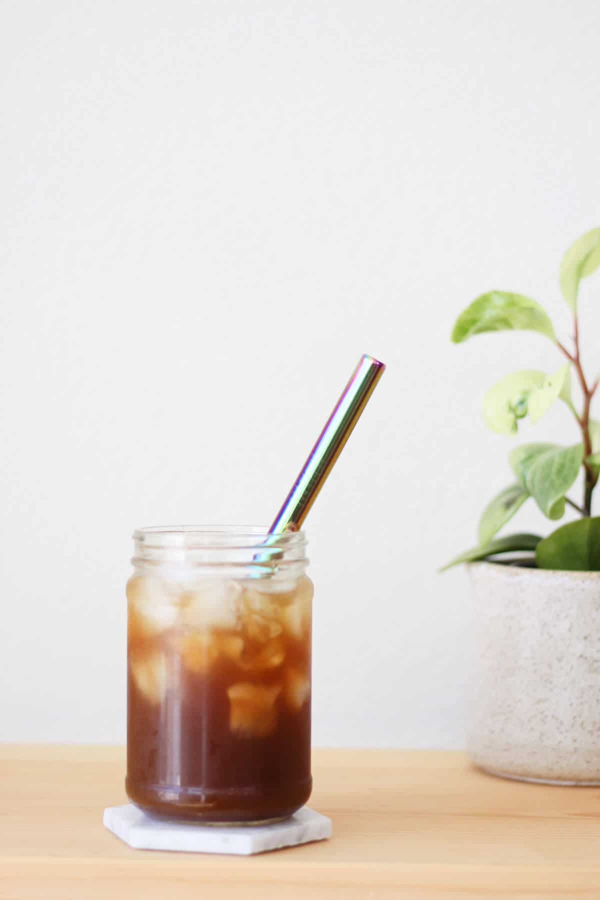 Clear glass filled with a shot of espresso and iced, then topped off with sparkling water and served with a metal straw.