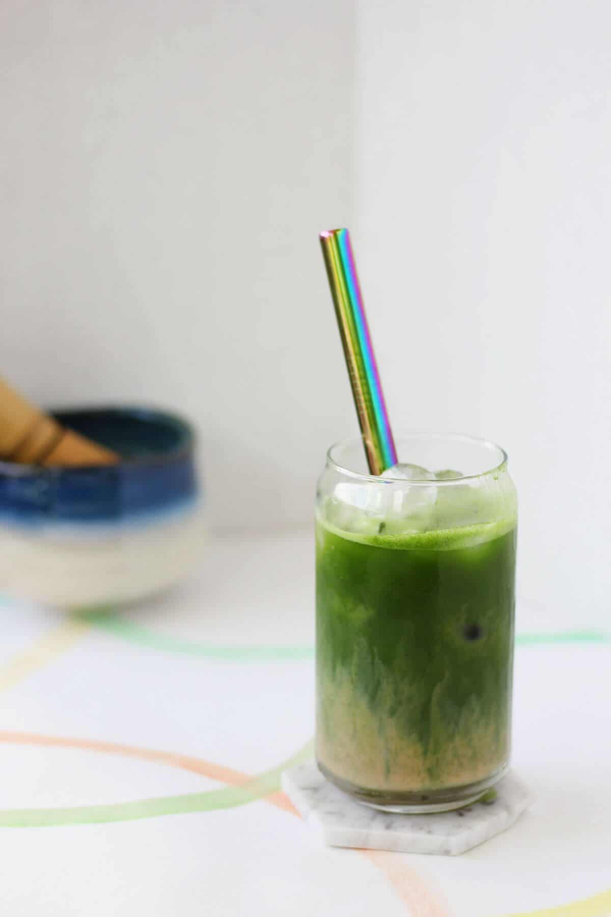 Clear glass filled with a layer of tan colored masala chai topped with bright green matcha.