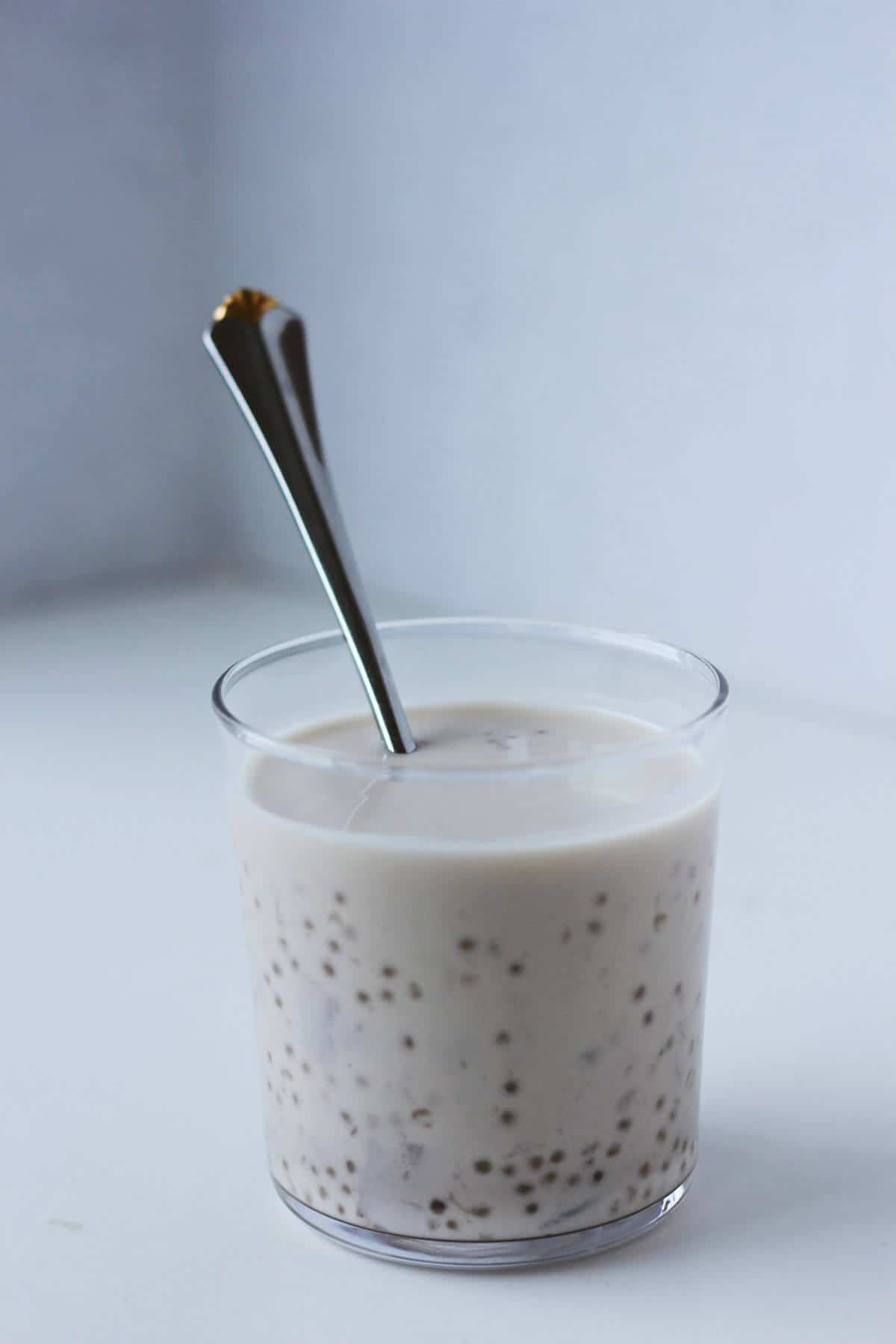 Clear cup filled with coconut milk, taro chunks and sago.